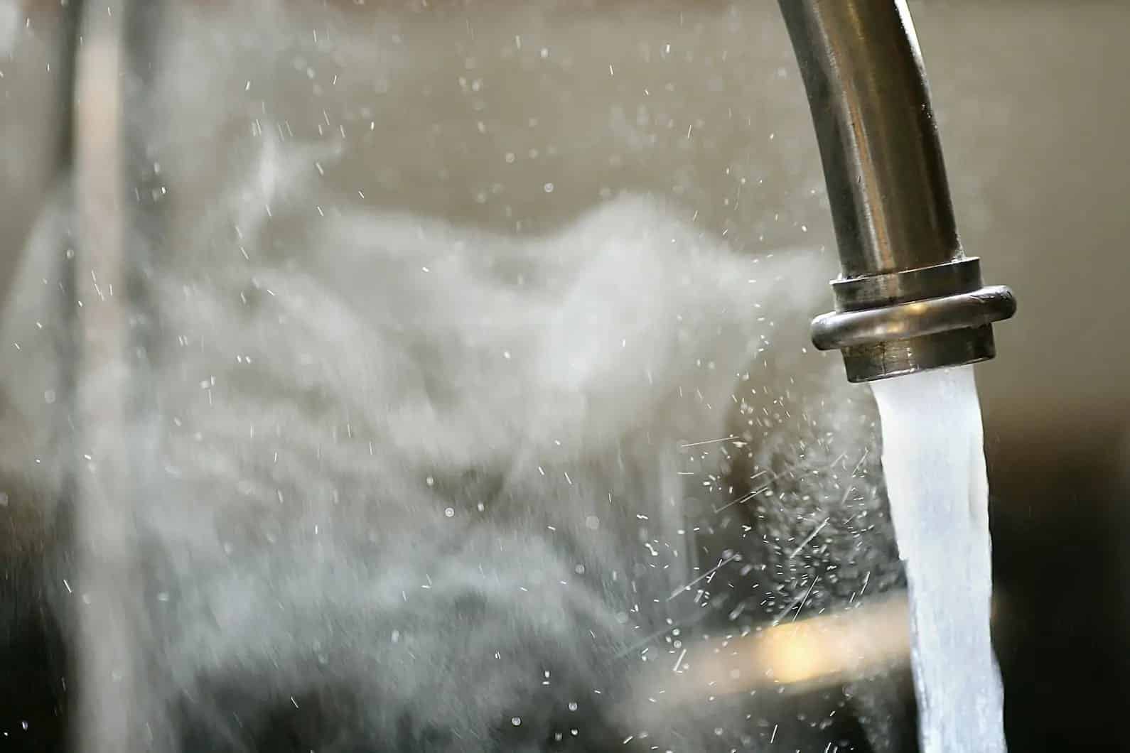Close up of kitchen sink with steamy hot water