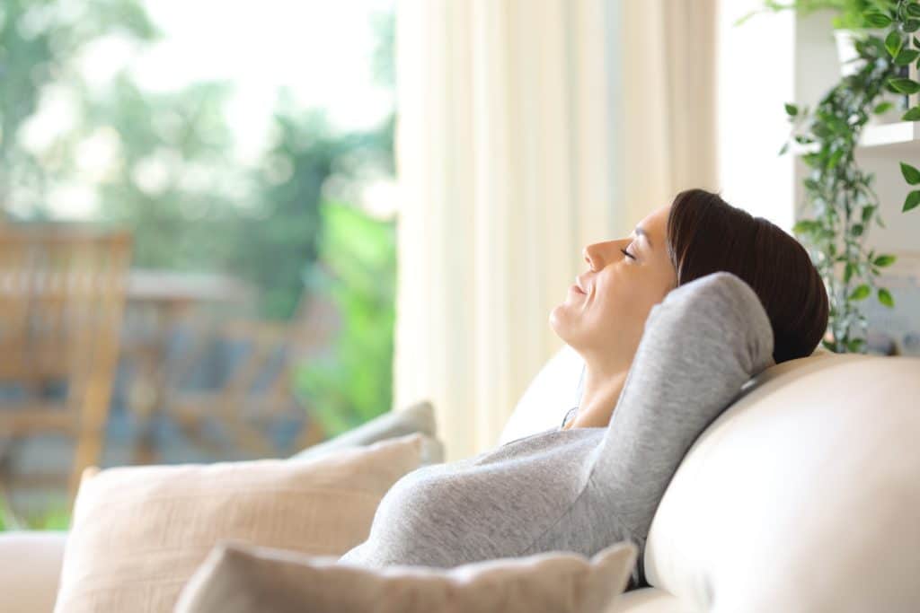 Woman relaxing sitting on a couch alone at home